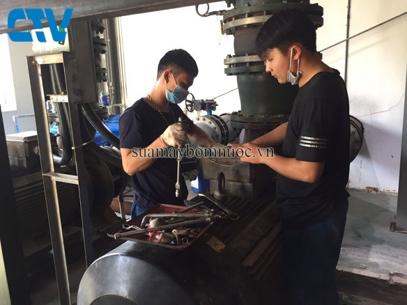 Nhân viên đang sửa máy bơm nước cho khách
